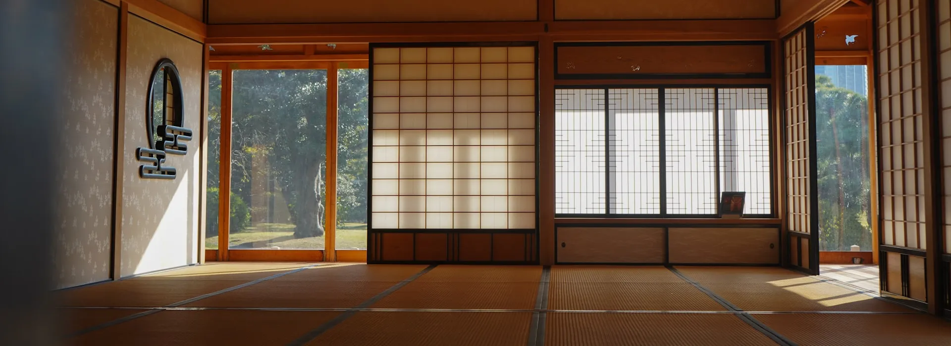 A quiet traditional Japanese tatami room with open shoji screens looking out onto a garden